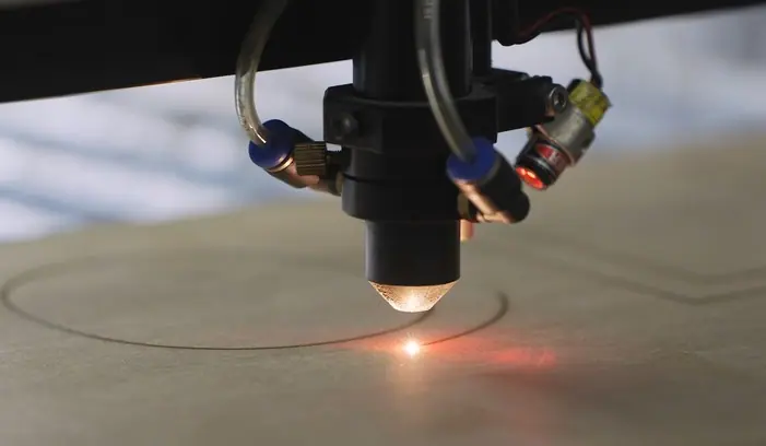 CO2 laser cutter cutting a board