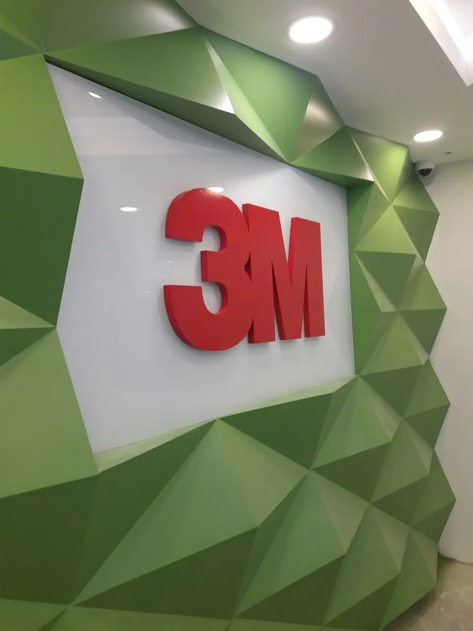 Dimensional logo sign on a faceted green feature wall