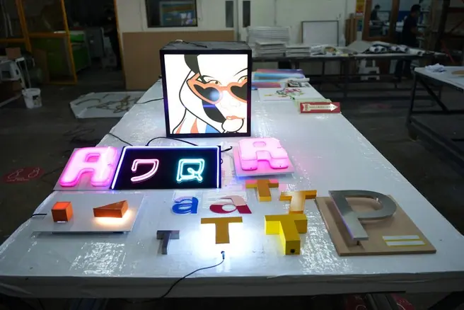 Lighted acrylic signs laid out in the workshop