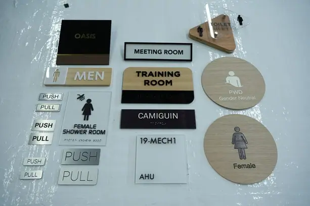 Assorted room ID and restroom signs in acrylic and wood