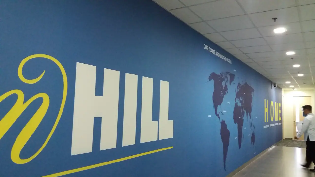 Corporate branding wall graphic along an office corridor